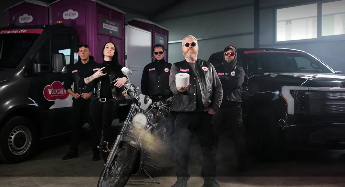 Zeigt Wölkchen-Mitarbeiter:innen vor einigen Wölkchen-Fahrzeugen. Die Mitarbeiter:innen sind in Biker-Outfits gekleidet.
